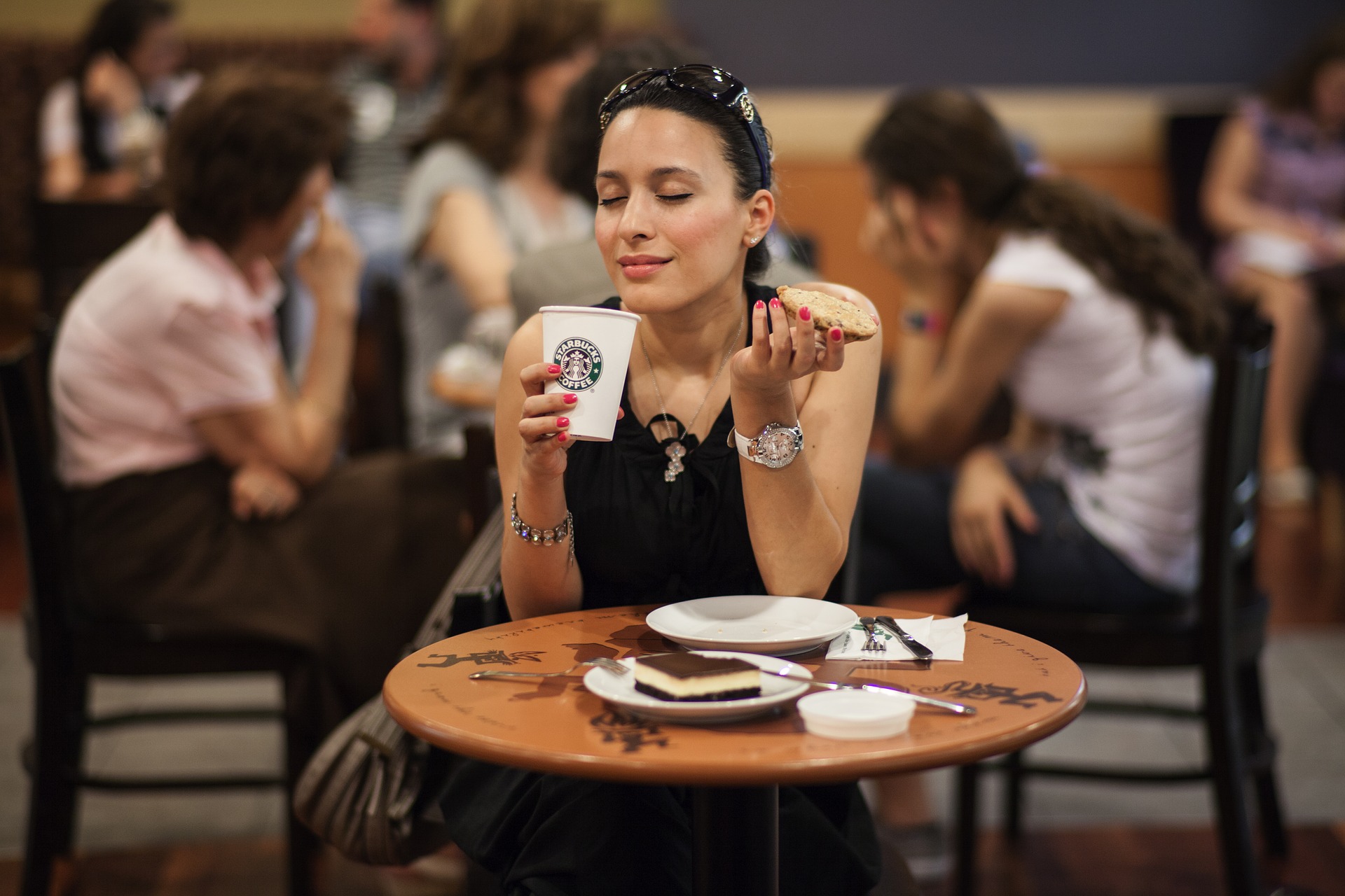 Mujer disfrutando un cafe y una tostada en Starbucks